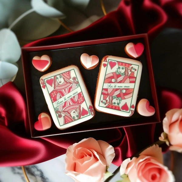 Biscuits personnalisés en forme de cartes à jouer Roi et Reine de cœur, réalisés à la main avec des détails soignés. Une touche royale pour une Saint Valentin mémorable.